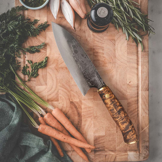 Roselli's handcrafted Santoku kitchen knife in high-carbon steel (UHC steel) with a stained curly birch handle. Delivered with a handmade leather sheath.